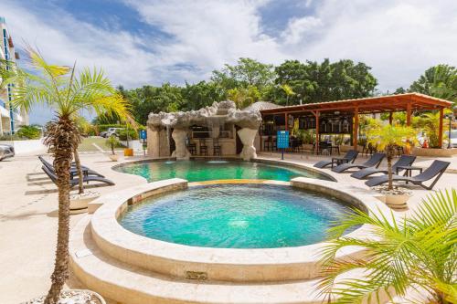una piscina con sillas y un cenador en Grand Laguna Beach Properties by Calisto Stays, en Sosúa