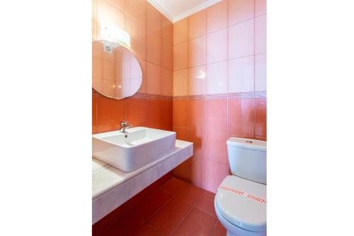 a bathroom with a toilet and a sink and a mirror at Villa Georgios in Plátonas