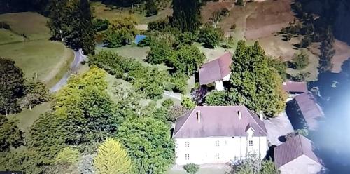 an aerial view of a white house in the middle of trees at LES TROIS L in Gindou
