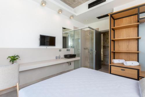 a bedroom with a king sized bed and a tv at Villa Angelos in Katelios