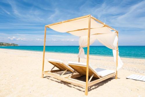 a beach chair with an umbrella on a beach at Villa Angelos in Katelios