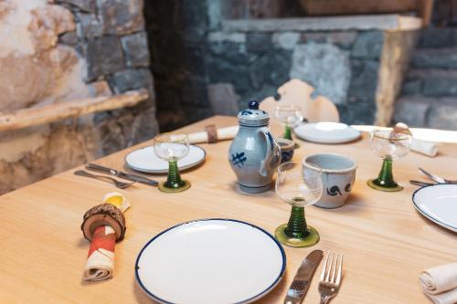 a wooden table with white plates and wine glasses at Huberhof in Fiè