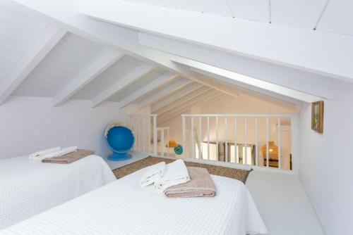 two beds in a room with white ceilings at Villa Alexandros in Gaios