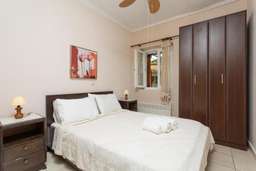 アギオス・ステファノスにあるFoteini Apartmentのベッドルーム(白い大型ベッド1台、キャビネット付)