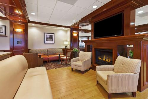 a waiting room with a fireplace and a flat screen tv at Hampton Inn Detroit/Southgate in Southgate