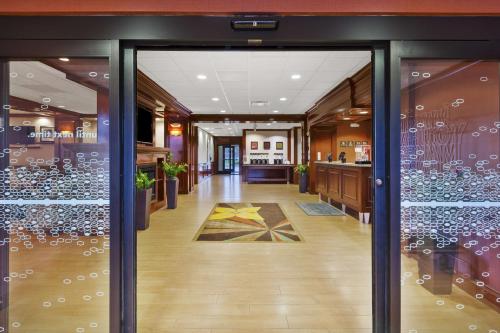 a glass door leading into a restaurant with wine bottles at Hampton Inn Detroit/Southgate in Southgate
