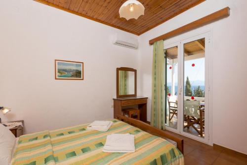 a bedroom with a bed and a view of a balcony at Dolphin Villa 1 in Porto Ozias