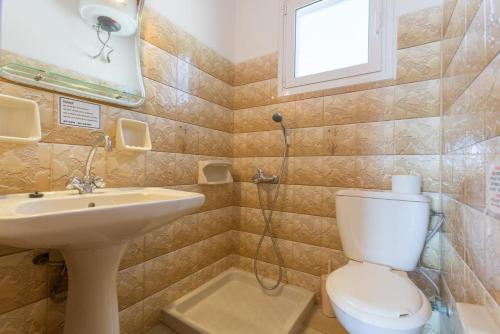een badkamer met een toilet, een wastafel en een raam bij Dolphin Villa 1 in Porto Ozias