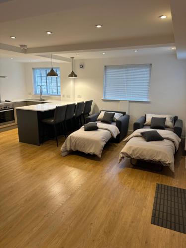 uma sala de estar com 2 camas e uma cozinha em The Pump House em St Ives
