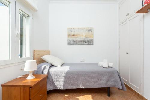 a bedroom with a bed and a table with a lamp at Villa Torreta in Punta Prima