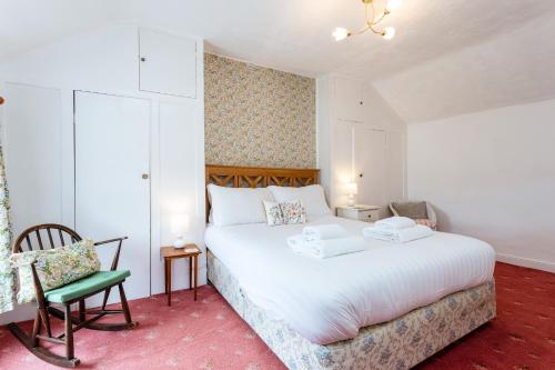 1 dormitorio con 1 cama blanca grande y 1 silla en Percy Cottages No4, en Alnmouth