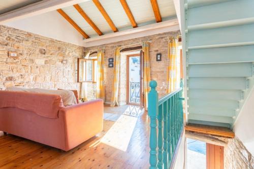 a living room with a couch and a stone wall at Spiros Jetty House in Longós