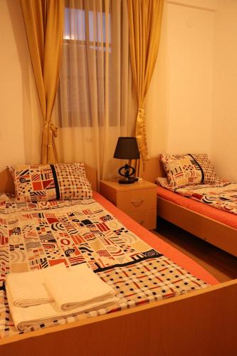 a bedroom with two twin beds and a window at Apartmani Marija in Ohrid