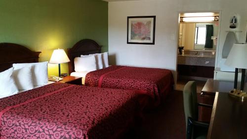 a hotel room with two beds and a mirror at Days Inn by Wyndham Santa Fe New Mexico in Santa Fe