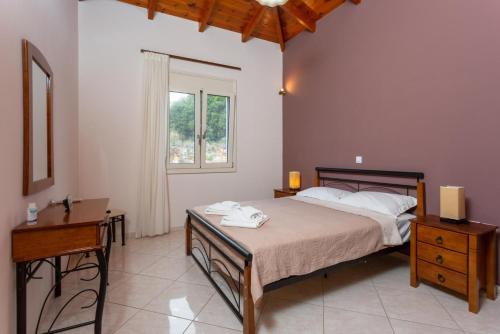 1 dormitorio con cama, escritorio y ventana en Villa Mary, en Gerani