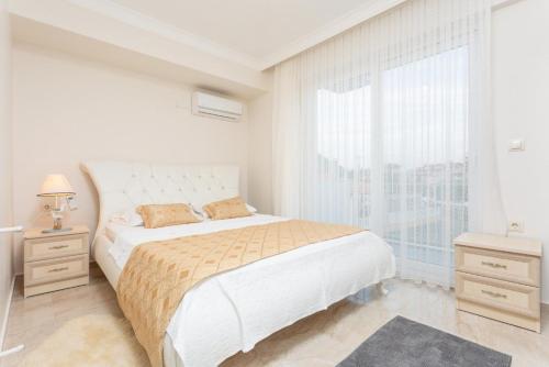 Un dormitorio blanco con una cama grande y una ventana en Villa Mina, en Muğla