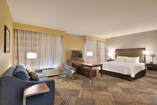 a hotel room with a bed and a desk at Hampton Inn & Suites Chippewa Falls in Chippewa Falls