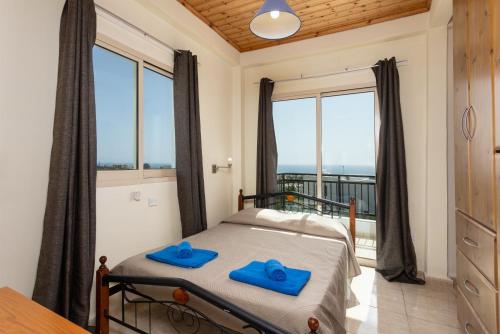 een slaapkamer met een bed met blauwe handdoeken bij Villa Solon in Peyia