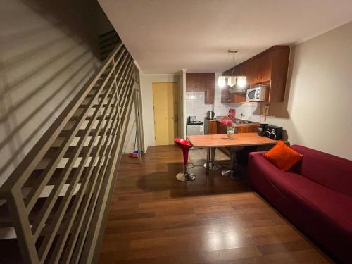 sala de estar con sofá rojo y mesa en VR Suite Santiago, en Santiago