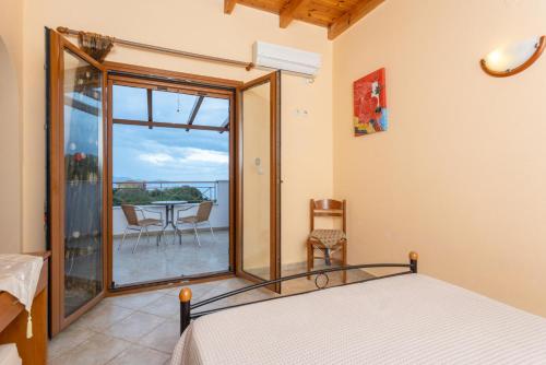 um quarto com uma cama e uma varanda com uma mesa em Villa Yeraki em Dhrapanítika