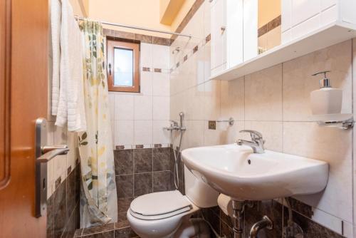 uma casa de banho com um lavatório e um WC em Villa Yeraki em Dhrapanítika