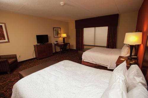 a hotel room with two beds and a television at Hampton Inn Elmira/Horseheads in Horseheads