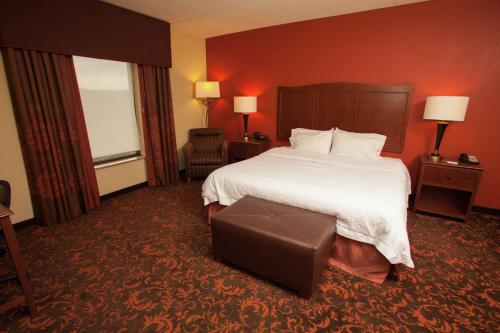 a hotel room with a large bed and a large window at Hampton Inn Elmira/Horseheads in Horseheads