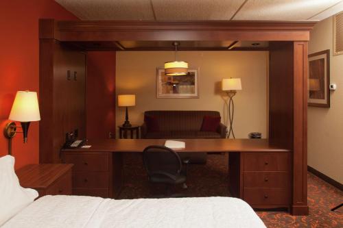 a hotel room with a desk and a couch at Hampton Inn Elmira/Horseheads in Horseheads
