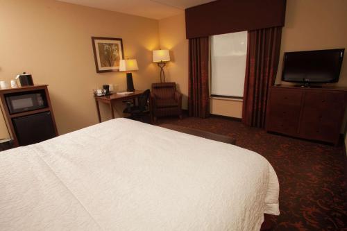 a hotel room with a bed and a flat screen tv at Hampton Inn Elmira/Horseheads in Horseheads