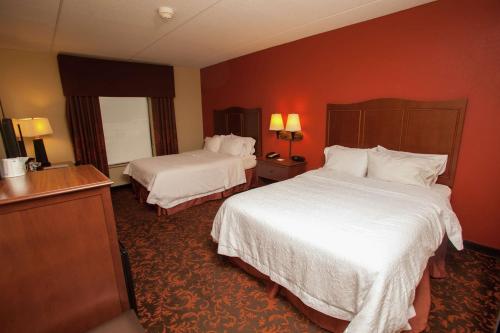 a hotel room with two beds and red walls at Hampton Inn Elmira/Horseheads in Horseheads
