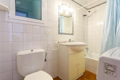 Baño blanco con aseo y lavamanos en Villa Bini Estrella, en Es Canutells
