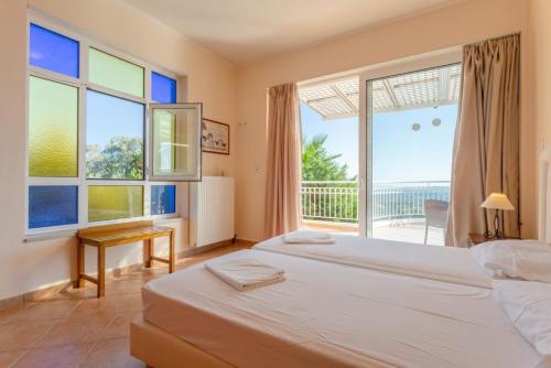 a bedroom with two beds and a large window at Villa Pelagos in Agia Triada