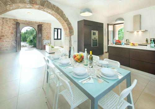 a dining room and kitchen with a blue table and chairs at Ses Cases Noves by Vintage Travel in Banyalbufar