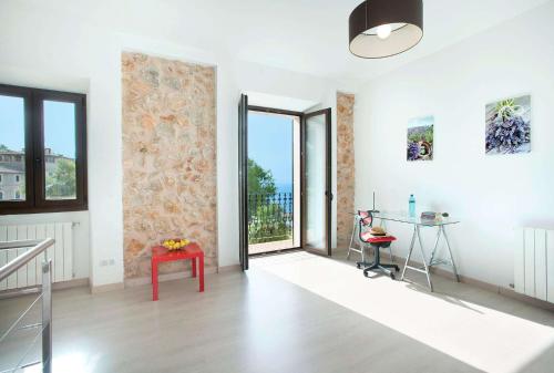 a white room with a door and a table and a desk at Ses Cases Noves by Vintage Travel in Banyalbufar