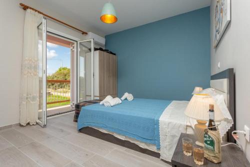 a blue bedroom with a bed and a sliding glass door at Vatsa Beach Villa in Kounopetra