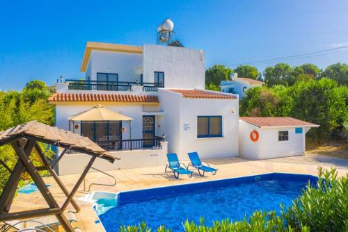 a villa with a swimming pool and a house at Villa Charoula Pente in Paphos