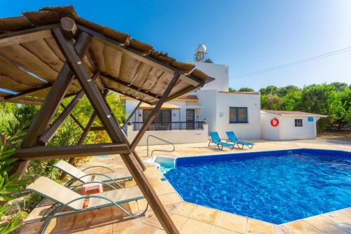 a villa with a swimming pool and a house at Villa Charoula Pente in Paphos