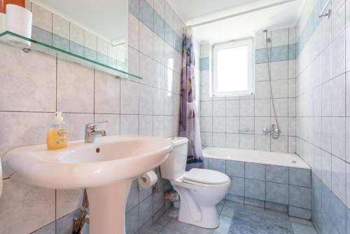 a white bathroom with a sink and a toilet at Villa Giannis in Áyios Andónios