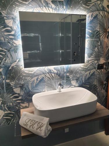 bagno con lavandino bianco e specchio di LUXURY HOLIDAY HOUSE a Diamante