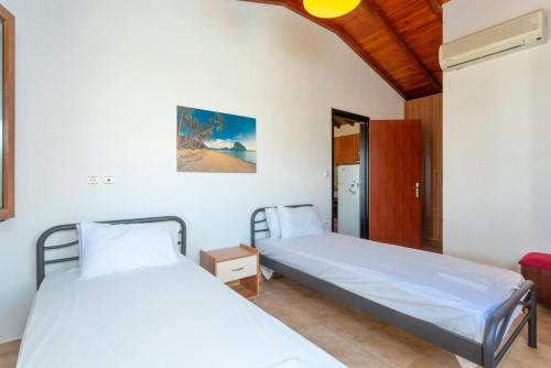 2 camas en una habitación con paredes blancas en Villa Katerina, en Panormos Skopelos