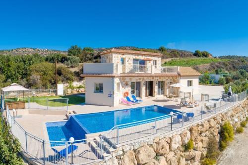 a villa with a swimming pool and a house at Villa Christel in Lachi
