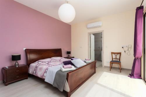 a bedroom with a bed and a purple wall at Villa Christel in Lachi