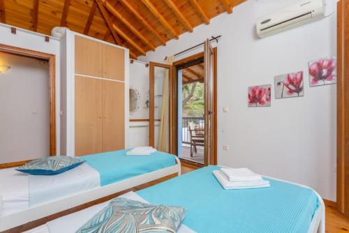 sypialnia z 2 łóżkami i balkonem w obiekcie Villa Glysteri w mieście Panormos