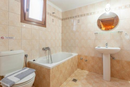 łazienka z wanną, toaletą i umywalką w obiekcie Villa Glysteri w mieście Panormos