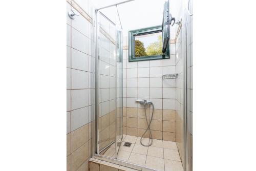 y baño con ducha y puerta de cristal. en Thanasis, en Dalietátika