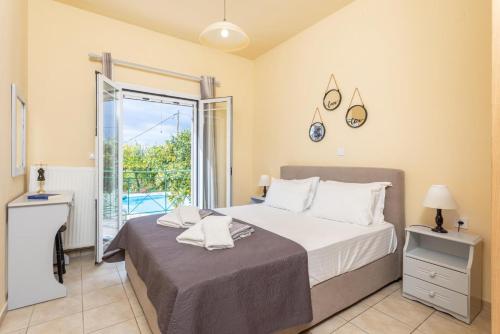 a bedroom with a large bed and a balcony at Villa Russa Dionisis in Trapezaki