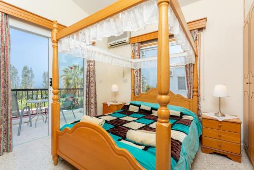 a bedroom with a canopy bed and a balcony at Argaka Sun Villa Ena in Argaka