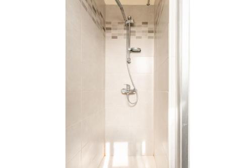 a shower in a bathroom with white tiles at Argaka Sun Villa Ena in Argaka