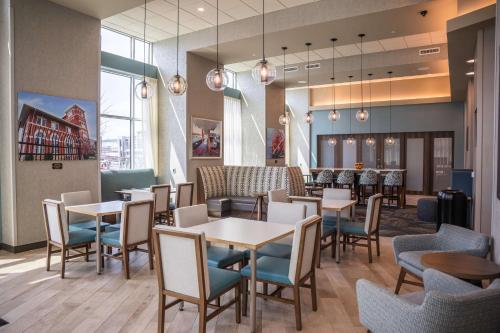 a restaurant with tables and chairs and a bar at Hampton Inn & Suites Erie Bayfront in Erie