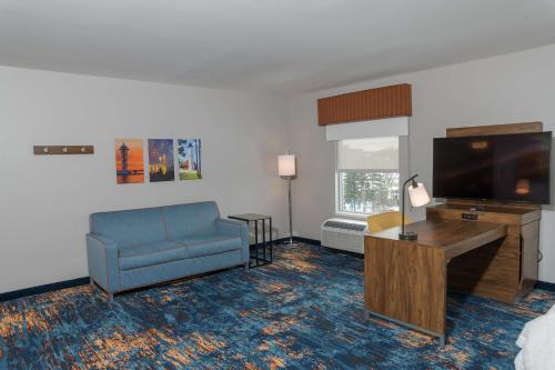 a living room with a blue couch and a television at Hampton Inn & Suites Erie Bayfront in Erie